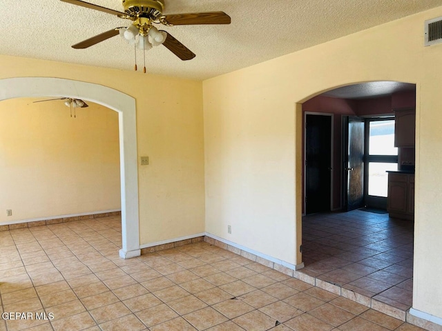 tiled spare room with ceiling fan and a textured ceiling