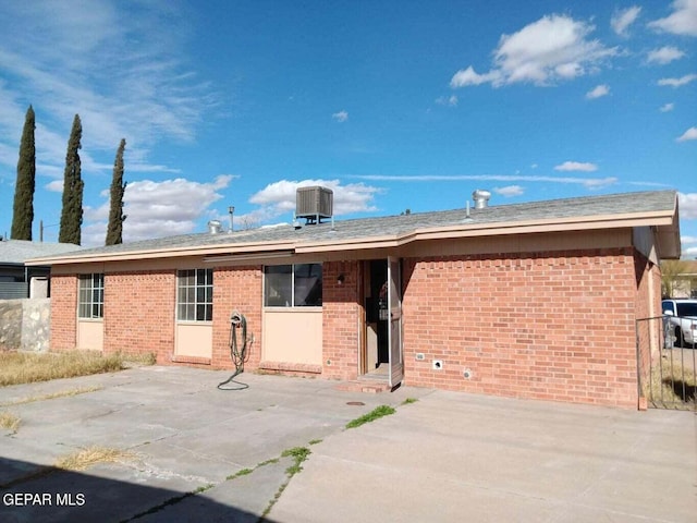 ranch-style house with cooling unit and a patio area