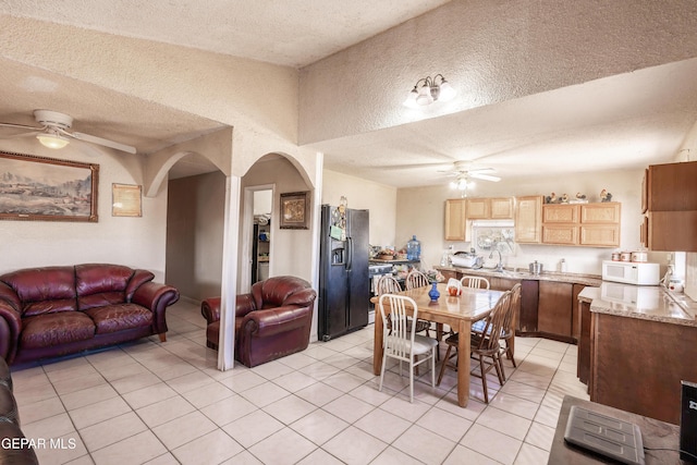 dining room featuring light tile patterned floors, a textured ceiling, and ceiling fan