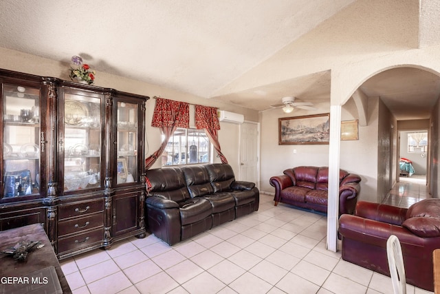 living room with ceiling fan, lofted ceiling, a wall mounted AC, and light tile patterned floors