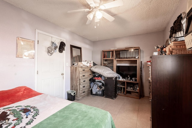 tiled bedroom featuring ceiling fan and a textured ceiling