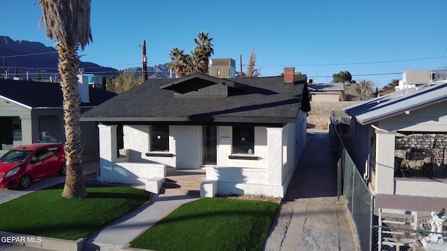 view of front of house with a front yard, covered porch, and cooling unit