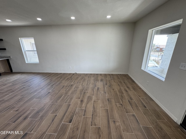 interior space featuring wood finish floors, plenty of natural light, baseboards, and recessed lighting