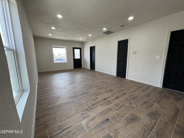 unfurnished room featuring wood finish floors, recessed lighting, baseboards, and visible vents