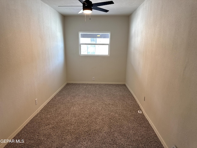 carpeted spare room with baseboards, a textured wall, and a ceiling fan