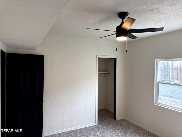 unfurnished bedroom with baseboards, a closet, carpet, and a textured ceiling