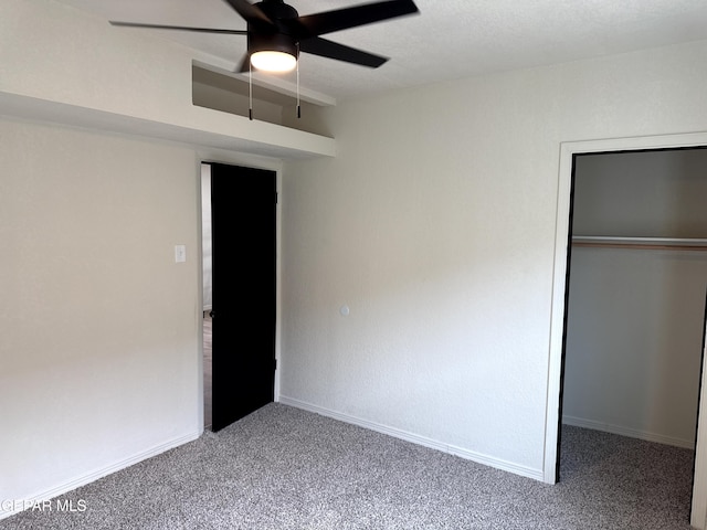 unfurnished bedroom with baseboards, a closet, carpet flooring, and a ceiling fan