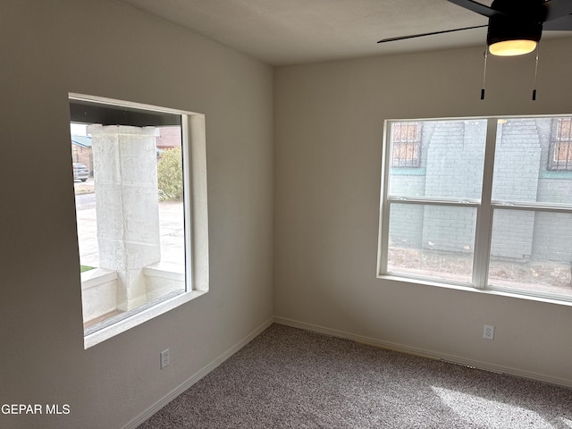 empty room featuring a ceiling fan, carpet floors, and baseboards