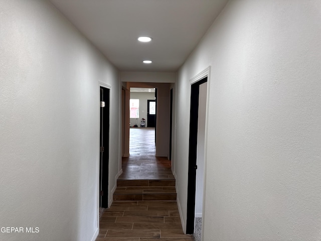 hall featuring wood tiled floor, recessed lighting, and baseboards