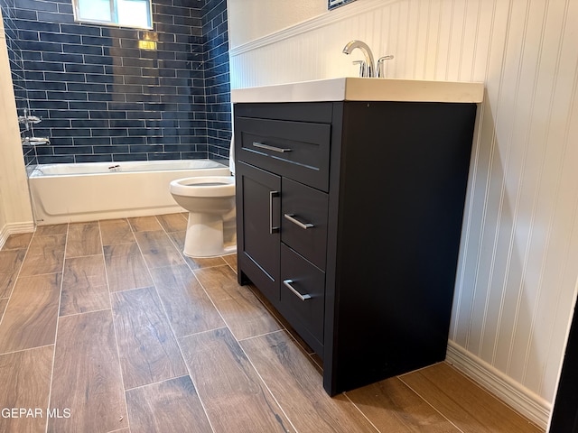 bathroom with tub / shower combination, toilet, vanity, and wood finish floors