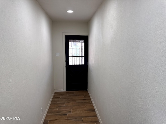 doorway with wood finish floors and baseboards