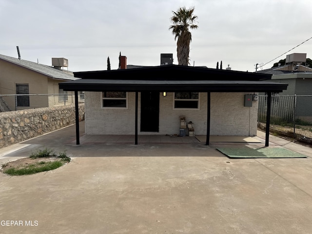 rear view of property featuring stucco siding, fence, and central AC unit