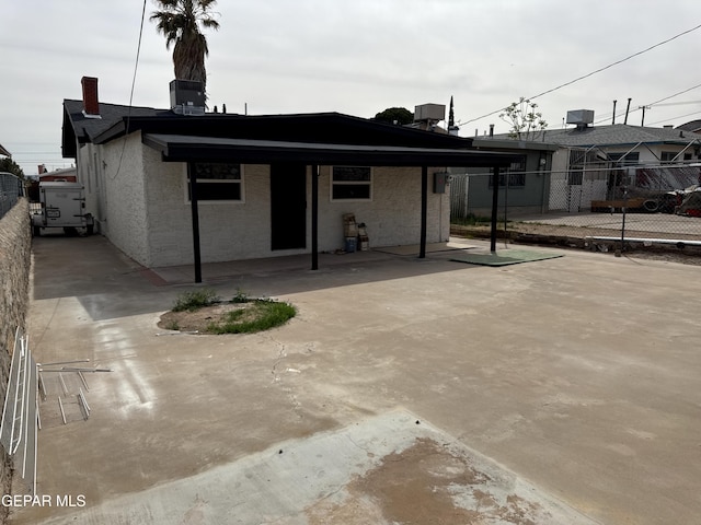 back of house featuring central air condition unit, a carport, fence, and a patio