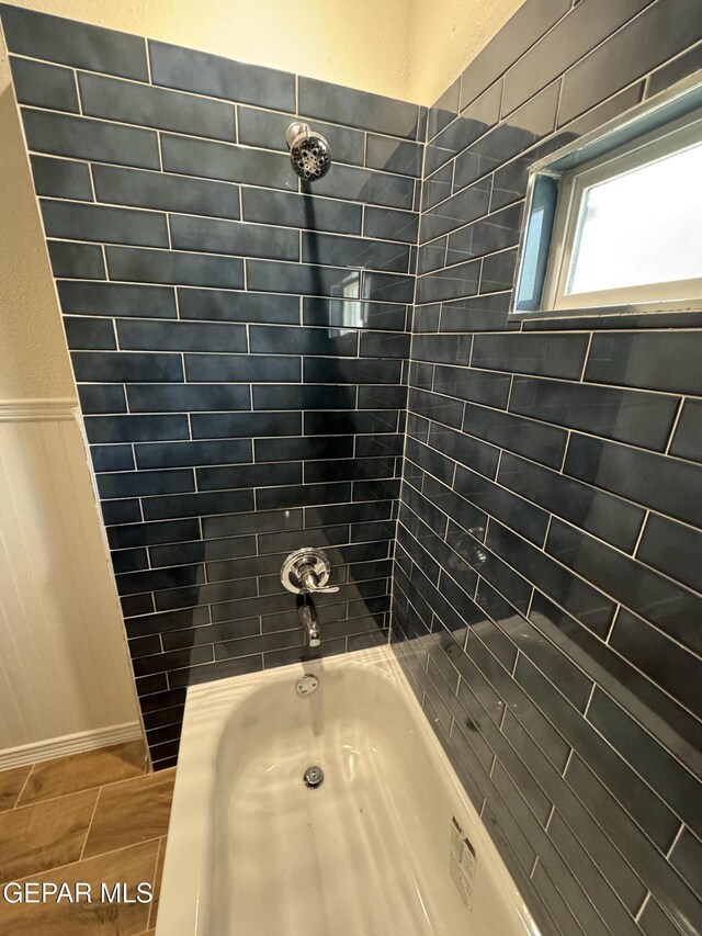 full bath with  shower combination and wainscoting