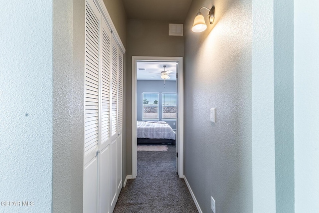 hallway featuring dark colored carpet