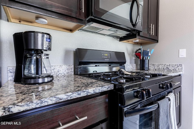 kitchen with light stone countertops, dark brown cabinets, and black appliances