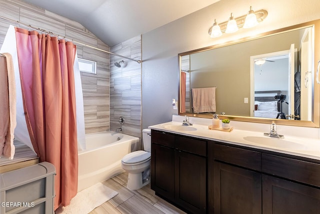 full bathroom featuring lofted ceiling, toilet, shower / bath combo with shower curtain, and vanity