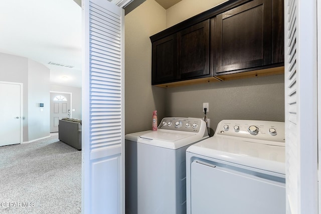 laundry area featuring cabinets, washing machine and dryer, and light colored carpet