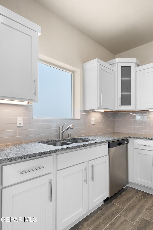 kitchen featuring white cabinetry, dishwasher, sink, decorative backsplash, and light stone counters