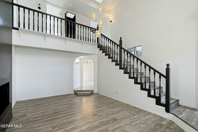 stairway with hardwood / wood-style flooring and a high ceiling