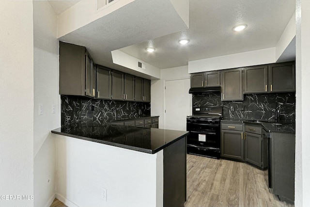 kitchen with sink, black range with gas stovetop, backsplash, kitchen peninsula, and light hardwood / wood-style flooring