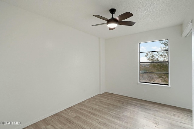 empty room with ceiling fan, a textured ceiling, and light wood-type flooring