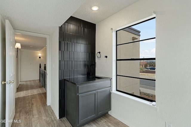 corridor with light hardwood / wood-style flooring and a textured ceiling