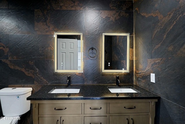 bathroom with vanity, tile walls, and toilet