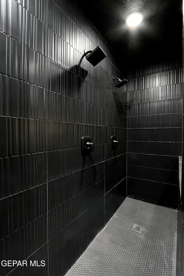 bathroom featuring tiled shower and a textured ceiling