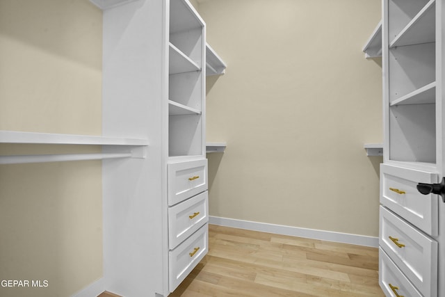 walk in closet with light wood-type flooring