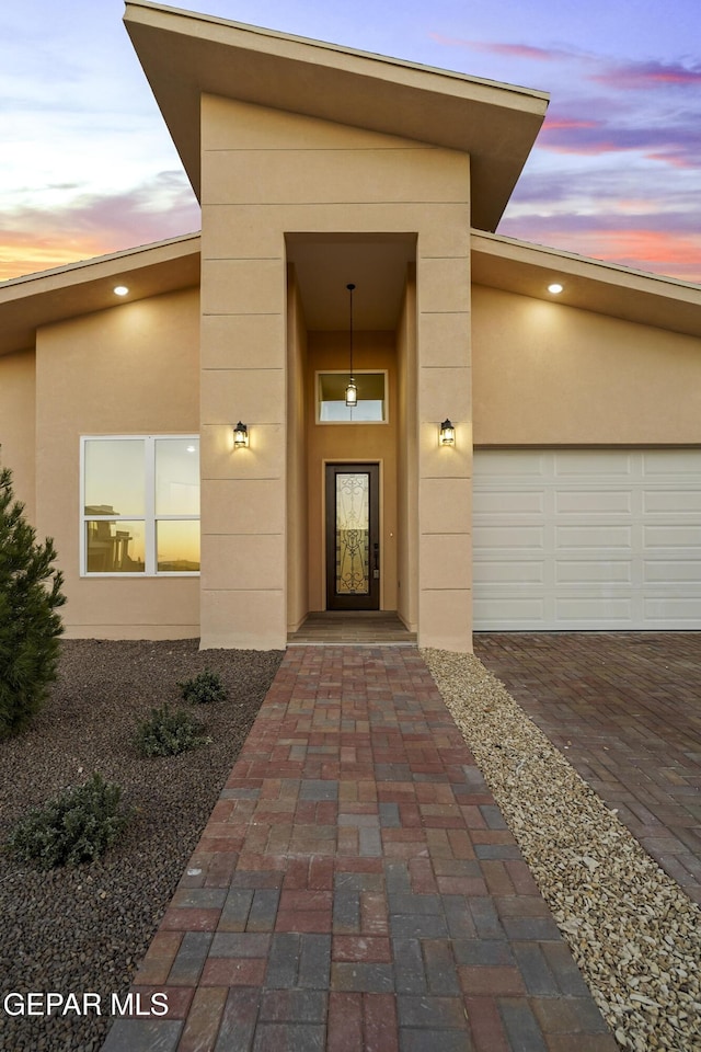 exterior entry at dusk with a garage