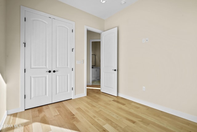 unfurnished bedroom featuring light hardwood / wood-style floors and a closet