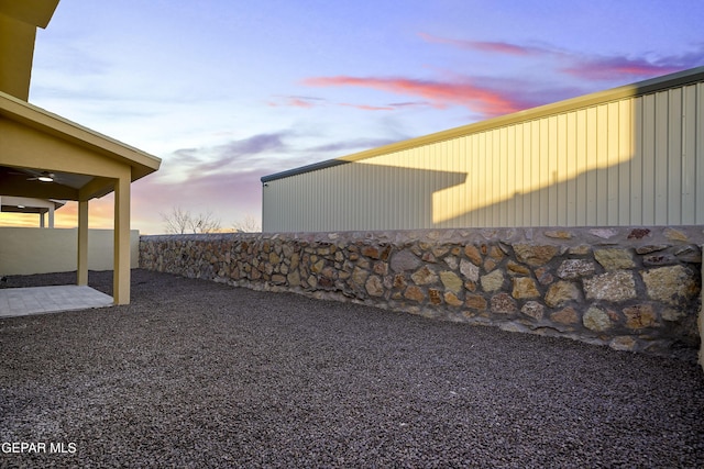 property exterior at dusk featuring a patio