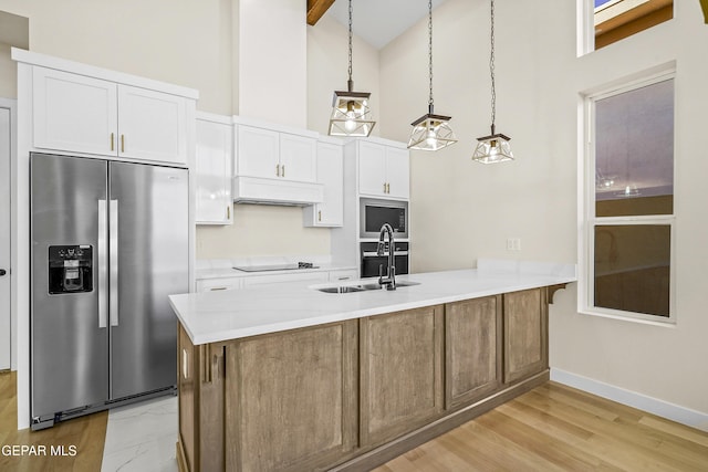 kitchen featuring stainless steel refrigerator with ice dispenser, built in microwave, sink, decorative light fixtures, and white cabinets