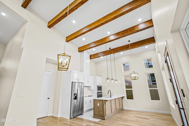 kitchen with white cabinetry, hanging light fixtures, and stainless steel appliances