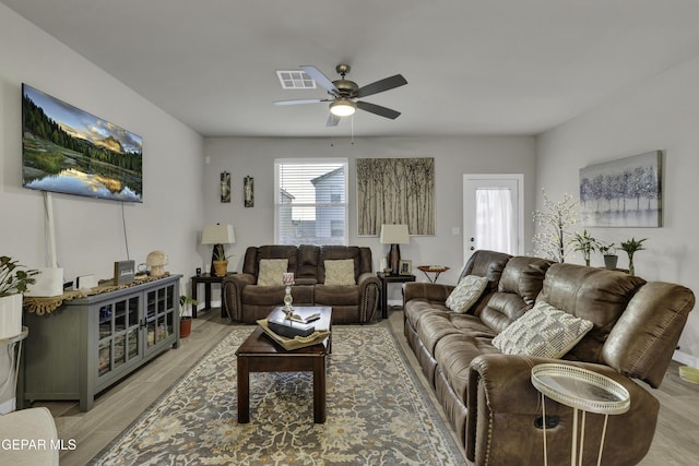 living room with ceiling fan, a wealth of natural light, and light hardwood / wood-style floors