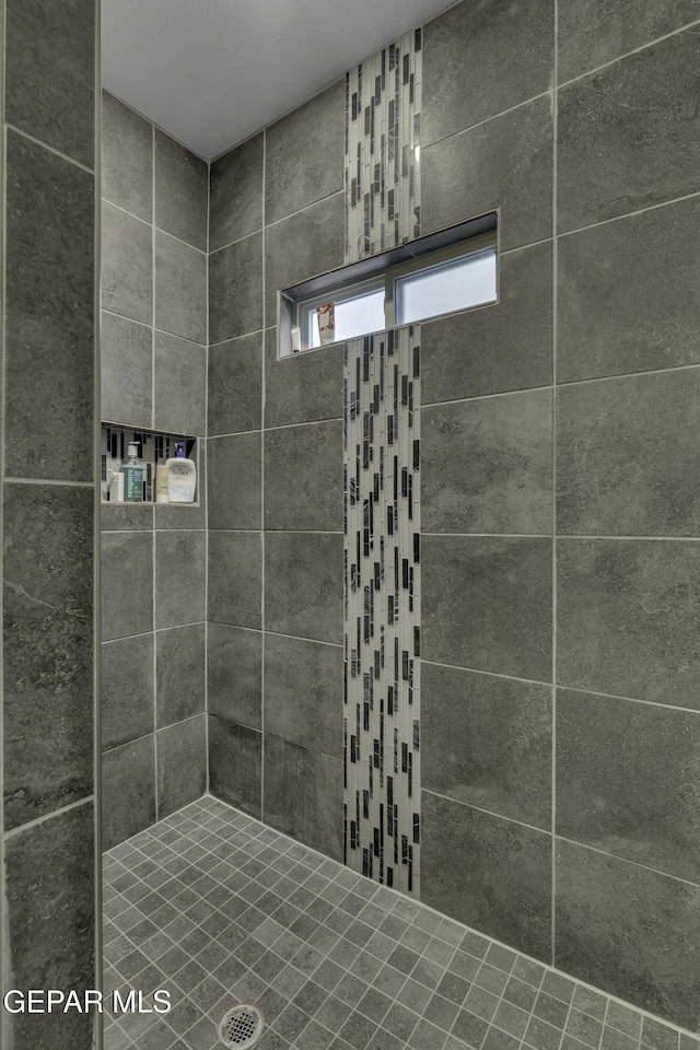 bathroom with tiled shower