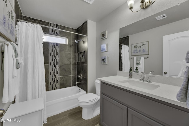 full bathroom featuring hardwood / wood-style flooring, vanity, toilet, and shower / tub combo