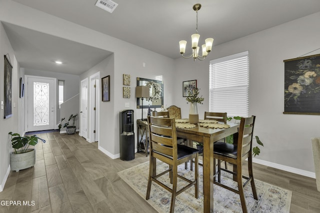 dining space featuring hardwood / wood-style flooring and a chandelier