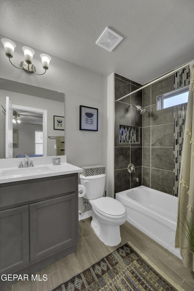 full bathroom with vanity, shower / tub combo, a textured ceiling, and toilet