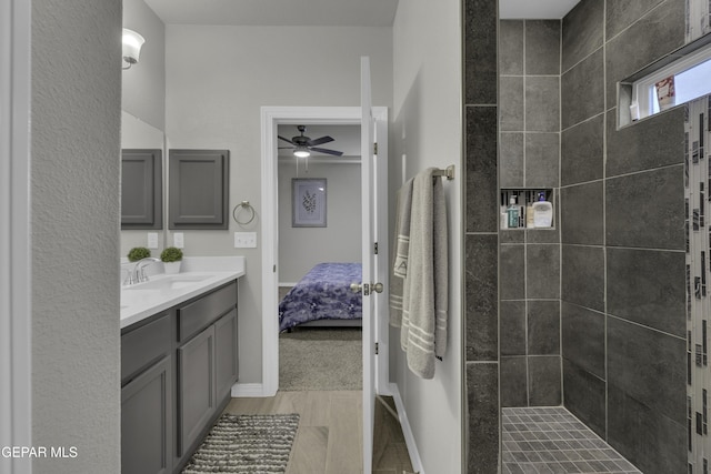 bathroom with vanity, wood-type flooring, and tiled shower