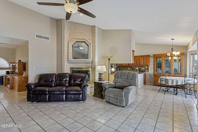 living room featuring light tile patterned flooring, a fireplace, ceiling fan with notable chandelier, and vaulted ceiling