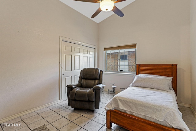 bedroom with light tile patterned floors, high vaulted ceiling, a closet, and ceiling fan