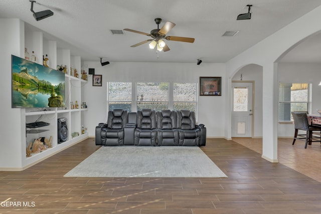 living room with plenty of natural light, hardwood / wood-style floors, a textured ceiling, and ceiling fan