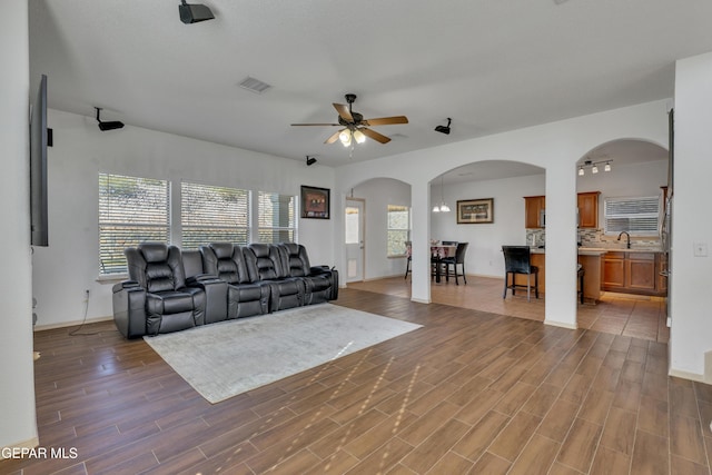 living room with dark hardwood / wood-style flooring, sink, and ceiling fan