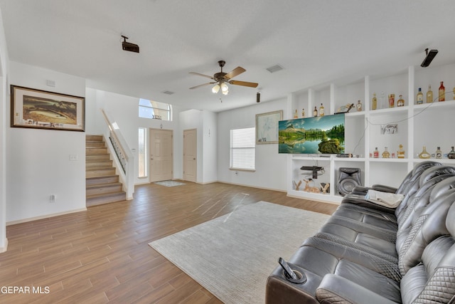 living room with ceiling fan and light wood-type flooring