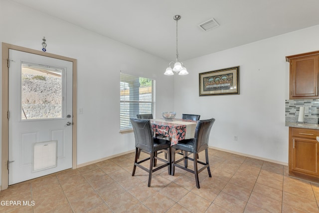 dining space featuring light tile patterned floors and a notable chandelier