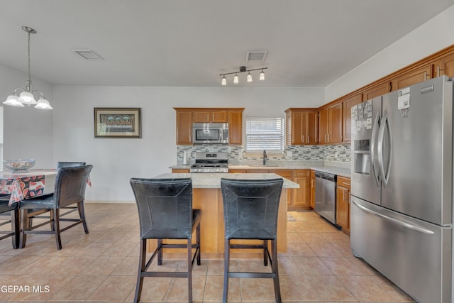 kitchen with tasteful backsplash, sink, a kitchen island, and appliances with stainless steel finishes