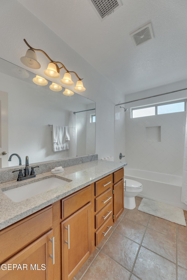 full bathroom with vanity, tiled shower / bath combo, a textured ceiling, and toilet