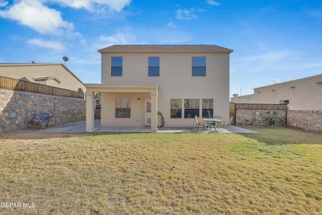 rear view of house featuring a lawn and a patio area